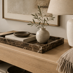 Brown marble tray styled on oak console table with lamp, ceramic vase and cashmere throw
