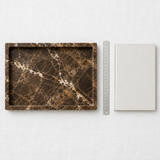 Brown marble tray flat-lay overhead shot with scale reference on white linen